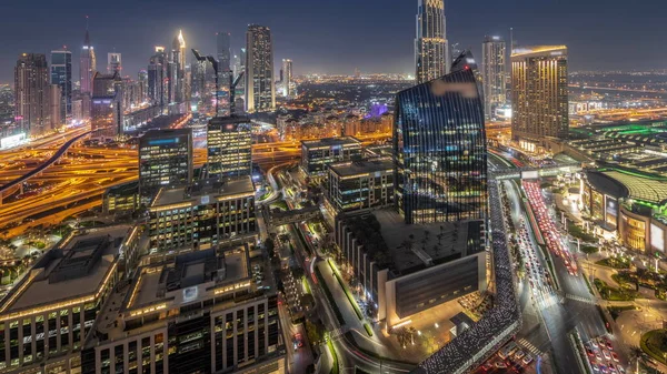 未来主义的迪拜下城和金融区的天际线全景从白天到夜晚的过渡 许多灯火通明的塔楼和摩天大楼 街上塞满了车辆 — 图库照片