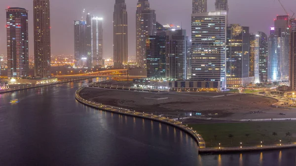 迪拜商业湾摩天大楼的城市景观与水渠空中的昼夜转换 日落后的现代天际线 塔楼和海滨 国际商务中心 — 图库照片