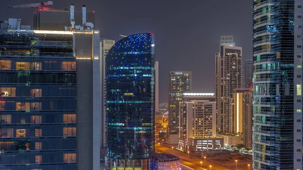 ドバイビジネスベイの高層ビルの街並と空中の交差点の夜 ライトアップされた塔や道路交通と現代のスカイライン 国際ビジネスの中心 — ストック写真