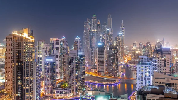迪拜滨海航站楼最高交接处的各种摩天大楼全景 白天到夜晚都是人工运河的过渡全景 日落后的许多塔楼和游艇 — 图库照片