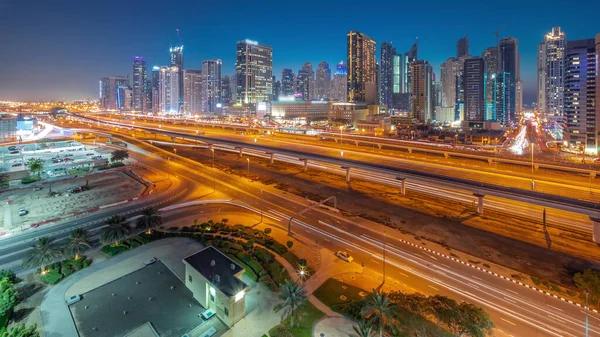 stock image Dubai Marina skyscrapers and Sheikh Zayed road with metro railway aerial day to night transition panoramic . Traffic on a highway near modern towers after sunset, United Arab Emirates