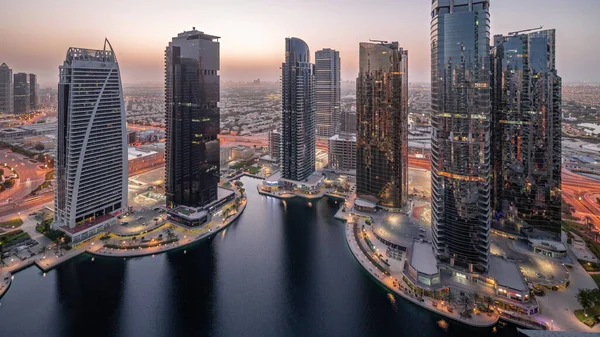 stock image Tall residential buildings at JLT district aerial night to day transition panoramic , part of the Dubai multi commodities centre mixed-use district. Skyscrapers before sunrise