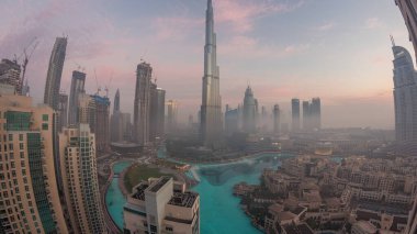 Sabahın erken saatlerinde, sis gecesinden gündüze geçerken Dubai şehrinin hava görüntüsü. Gökdelenleri ve kuleleri olan gelecekçi şehir gökdelenleri ve gökdelenleri yukarıdan gün doğumunda