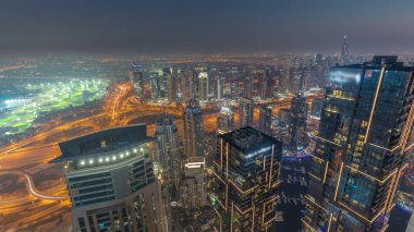 Panorama of Dubai Marina with JLT skyscrapers day to night transition , Dubai, United Arab Emirates. Aerial view from above towers after sunset with traffic on highway