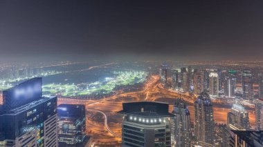 Panorama of Dubai Marina with JLT skyscrapers and golf course night , Dubai, United Arab Emirates. Aerial view from above towers. City lights illumination