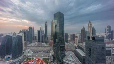 Panorama of futuristic skyscrapers with sunset in financial district business center in Dubai on Sheikh Zayed road . Aerial view from above with colorful cloudy sky