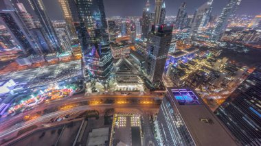 Şeyh Zayed 'in yol gecesinde Dubai' deki finans merkezindeki gökdelenlerin panoraması. Aydınlatılmış kulelerle yukarıdan aşağıya bakan hava manzarası