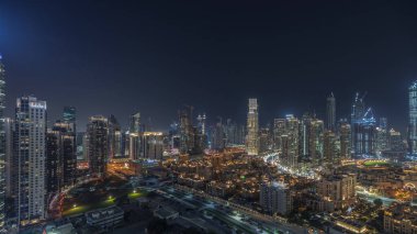 Panorama showing Dubai Downtown and business bay night  with tallest skyscraper and other illuminated towers view from the top in Dubai, United Arab Emirates.