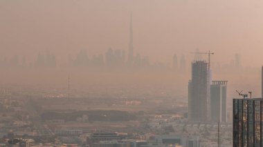 Dubai Şehir Merkezi 'nin finans bölgesi gökdelenler silsilesiyle sabah puslu havasında gökdelenler. Dubai yat limanının çatısından çok uzakta. Gün doğarken villalar. BAE