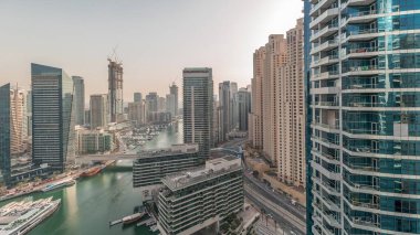 Panorama showing overview to JBR and Dubai Marina skyline with modern high rise skyscrapers waterfront living apartments aerial . Yachts floating on water of canal. JLT district on a background