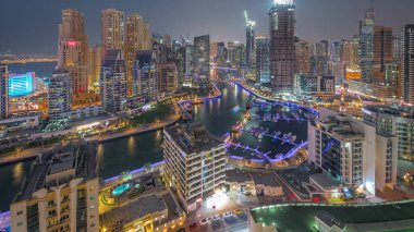 Dubai Marina 'da limana park etmiş birkaç tekne ve yatla ve hava kanallarının etrafındaki gökdelenlerle. JBR bölgesinin kuleleri ve vinçli şantiye