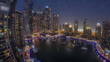 Dubai marinası en uzun gökdelenler panorama ve yat liman havadan geceye gün batımından sonra geçiş. Apartman binalarına, otellere ve ofis bloklarına, BAE 'nin modern yerleşim alanlarına bak