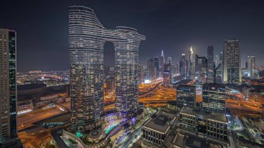 Panorama showing futuristic Dubai Downtown and finansial district skyline aerial night . Many illuminated towers and skyscrapers with traffic on streets