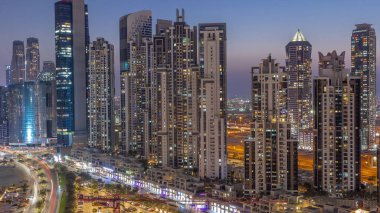 Business Bay hava sahasında modern kuleleri olan körfez bulvarı, gündüzden geceye geçiş, Dubai, BAE. Gün batımından sonra gökdelenler