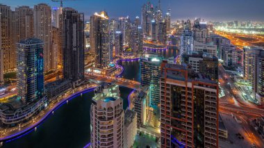 Dubai Marina hava sahasının en yüksek bloğundaki çeşitli gökdelenleri gece gündüz yapay kanallar ve köprüler ile görmek. Gün batımından sonra birçok kule ve yat