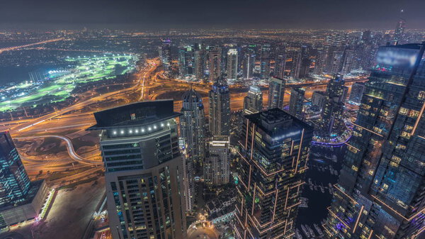 Panorama of Dubai Marina with JLT skyscrapers and golf course day to night transition , Dubai, United Arab Emirates. Aerial view from above towers after sunset