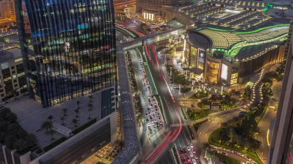 Aerial panorama of Downtown Dubai with shopping mall and traffic on a street day to night transition  from above, UAE Modern skyscrapers and hotels