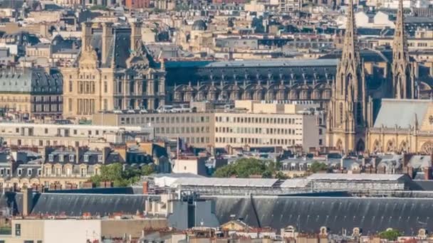 パリのタイムラプスの屋上の家の屋根の上の空中パノラマ 博物館や大聖堂の尖塔とフランスの旗を持つ夕景は日没を負担 — ストック動画