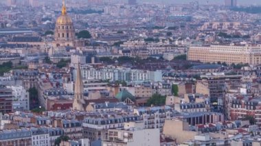 Paris 'teki evlerin çatılarının üstündeki hava panoraması gece gündüz geçiş zamanı. Günbatımından sonra aydınlanan kubbe ve diğer manzaralarla akşam manzarası