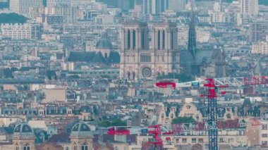 Paris 'teki evlerin çatılarının üstündeki hava panoraması gece gündüz geçiş zamanı. Notre Dame de Paris 'in akşam manzarası ve Saint-Sulpice gün batımından sonra aydınlandı.