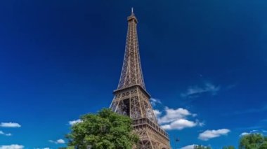 Eyfel Kulesi, Paris 'teki Siene nehri kıyılarından Fransa' nın Timelapse hiperlapse bölgesinin yakın görüntüsü. Yazın mavi bulutlu gökyüzü Yeşil ağaçlar ve etrafta yürüyen insanlar