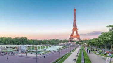 Fransa 'nın başkenti Paris' teki Jardins du Trocadero 'da bulunan Eiffel Kulesi' nin günbatımı panoramik görüntüsü. Uzun gölgeler. Etrafta dolaşan insanlar. Eyfel Kulesi, Paris 'in en ikonik simgelerinden biridir..