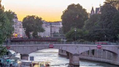 Sen nehri kıyısı ve Notre Dame De Paris katedrali yakınlarındaki köprü. Gün batımından sonra geçiş zamanı. Tournelle Köprüsü 'nden görüntü. Arka planda turuncu gökyüzü. Paris, Fransa, Avrupa.