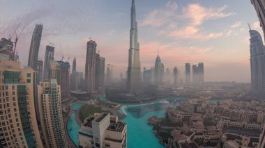 Sabahın erken saatlerinde, sis gecesinden gündüze geçiş zamanlarında Dubai şehrinin hava görüntüsü. Gökdelenleri ve kuleleri olan gelecekçi şehir gökdelenleri ve gökdelenleri yukarıdan gün doğumunda