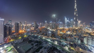 Dubai Şehir Merkezi, tüm gece boyunca, Dubai 'nin en yüksek gökdeleni ve diğer aydınlatma kuleleri olan Birleşik Arap Emirlikleri manzaralı panorama boyunca. Gökyüzünde ay ve ışıklar sönüyor