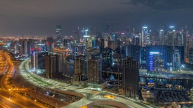 Dubai 'nin modern mimarisine sahip Skyline tüm gece panoramik zaman dilimi boyunca kuleleri aydınlattı ve ışıklar söndü. Kanal ve şantiyeli hava manzarası