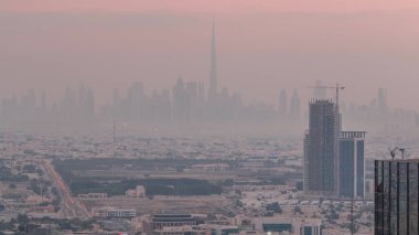 Dubai Şehir Merkezi 'nde gökdelenlerle dolu bir gökdelen silueti var. Dubai yat limanının çatısından çok uzakta. Villa evleri güneş doğmadan önce. BAE