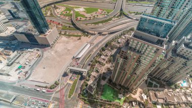 Gökdelenler arasındaki yol kesişiminin havadan görünüşü tüm gün boyunca gölgelerin hızlı hareket ettiği bir zaman dilimi boyunca düşüktür. BAE 'nin Dubai Marina bölgesinin şehir manzarası. Arabaları ve tramvayı var.