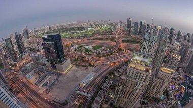 Dubai marinası ve medya şehri olan JLT gökdelenleri Sheikh Zayed Yolu 'ndaki hava gününden geceye geçiş zamanı. Konut ve ofis binaları yukarıdan panorama.