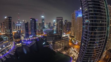 Dubai marinasına giden hava manzarası kanalın etrafındaki gökdelenleri aydınlattı. Tüm gece boyunca yüzen yatlar panorama boyunca ışıklar kapalıydı. Yat kulübünde beyaz tekneler var.