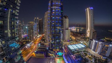 Dubai Marina ve JBR bölgesinin panoraması ve ünlü Ferris Wheel hava gününden geceye geçiş zamanı. Basra Körfezi 'nde gün batımından sonra altın kum plajları