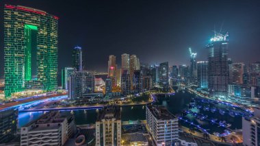 Dubai Marina Panoraması 'nda limana parkedilmiş tekneler ve tüm gece boyunca kanalın etrafında aydınlık gökdelenler vardı. Arka planda JBR kuleleri ve ışıkları kapatılmış