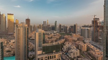Gün batımında büyük, fütüristik bir şehrin göksel panoramik ufuk çizgisini gösteren panorama. Gökdelenleri ve geleneksel evleri olan iş sahası ve şehir merkezi bölgesi, Dubai, Birleşik Arap Emirlikleri