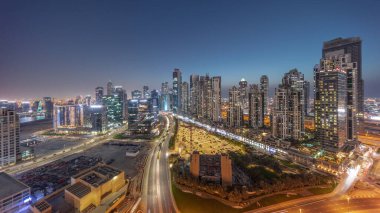 Bay Bulvarı 'nın Panorama' sı, Business Bay hava sahasında modern kuleler, gündüz, gece geçiş zamanı, Dubai, BAE. Büyük otoparkın yakınındaki yolda trafiği olan gökdelenler.