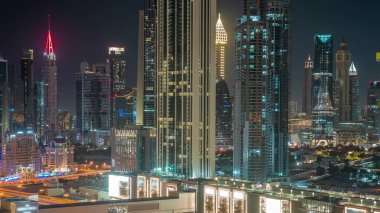 Earth hour with lights turning off and on. Towers around Sheikh Zayed Road and DIFC district aerial with and without night illumination in Dubai, UAE. International Financial Centre skyscrapers