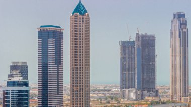 Dubai İş Koyu 'nun şehir manzaralı gökdelenleri ve su kanalları zaman ayarlı. İnşaat ve rıhtım altındaki kulelerin gölgeleriyle modern gökyüzü. Uluslararası bir iş merkezi.