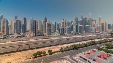 Dubai marinasının panoraması tüm gün boyunca gökdelenlerin en yüksek binası. JLT bölgesinden apartman binalarına, otellere ve otoyolun yakınındaki gölgeli iş kulelerine hava manzarası