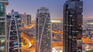 JLT bölge hava sahasında bulunan uzun binalar, Dubai çok amaçlı emtia merkezi karma kullanım bölgesinin bir parçası olan gece geçiş zamanına kadar. Arka planda villalar ve yol trafiği