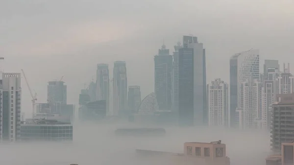 ビジネスベイ地区の夜から昼への移行時間経過で朝霧とドバイの高層ビル アラブ首長国連邦のダウンタウンの上からの空中ビュー — ストック写真