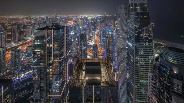 全景显示迪拜码头与Jlt和Jbr区 摩天大楼之间的高速公路上的交通夜间飞驰而过 照明现代化塔和建筑工地 — 图库照片
