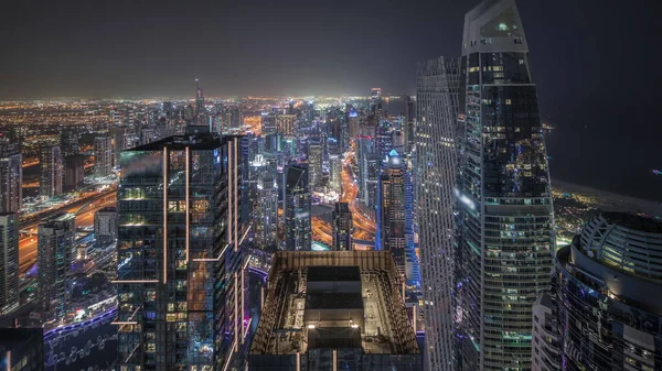 全景显示Jbr区和迪拜码头与Jlt 摩天大楼之间的高速公路上的交通夜间飞驰而过 照明现代化塔和建筑工地 — 图库照片