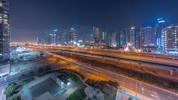 迪拜码头摩天大楼的全景和谢赫扎耶德公路与地铁空中的昼夜过渡时间 阿拉伯联合酋长国日落后靠近现代塔楼的高速公路上的交通情况 — 图库照片