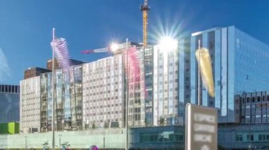 Yüksek gökdelenleri, güneş yansıtmalı binaları ve metro istasyonundan çıkışlı vinçleri olan La Defence zaman atlaması, iş ve finans bölgesi panoraması