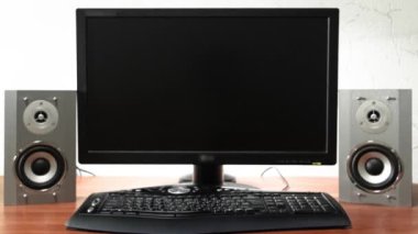 Bilgisayar, ses hoparlörleri ve klavye zaman ayarlı yüksek hızda dijital iş için çalışma masası. Ekranı kapatan ve siyah monitöre kayan ileri hareket