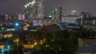 Moskova 'nın çatıdaki zaman çizelgesinden bir gece. Karanlık çöktüğünde konut binaları. Tren istasyonunun yanındaki çatıdan akşam manzarası. Pencerelerde ışık var. Bulutlu gökyüzü