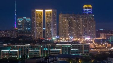 Moskova 'nın çatıdaki zaman çizelgesinden bir gece. Geceleri apartmanlar ve Ostankinskaya TV kulesi. Çatıdan gece manzarası. Pencerelerde ışık ve yolda trafik
